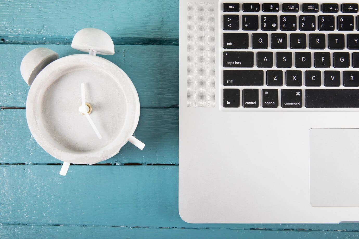 Vækkeur og bærbar computer, der symboliserer tidsregistrering og lovkrav i 2024.