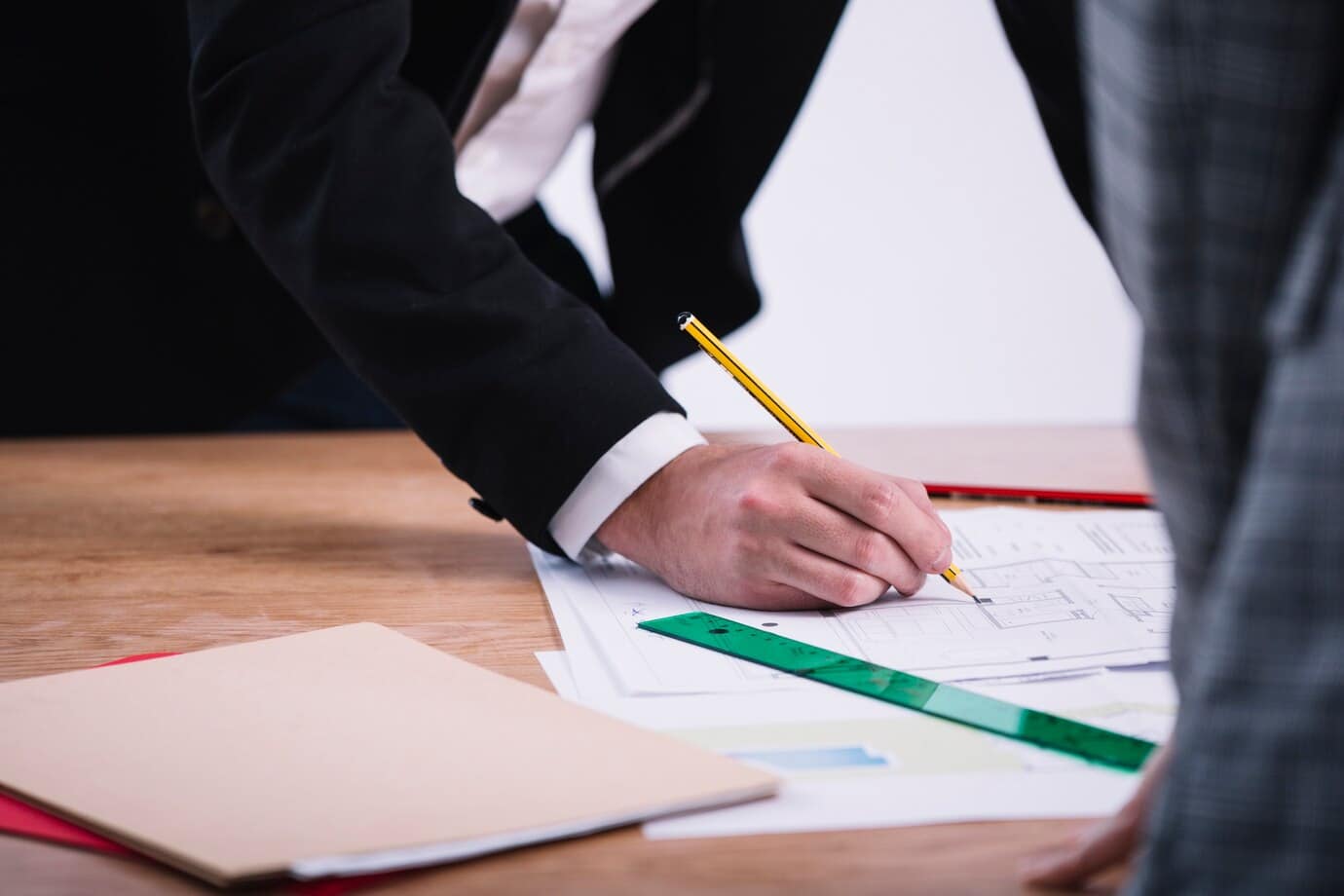 To personer arbejder på et udkast med blyant og lineal.