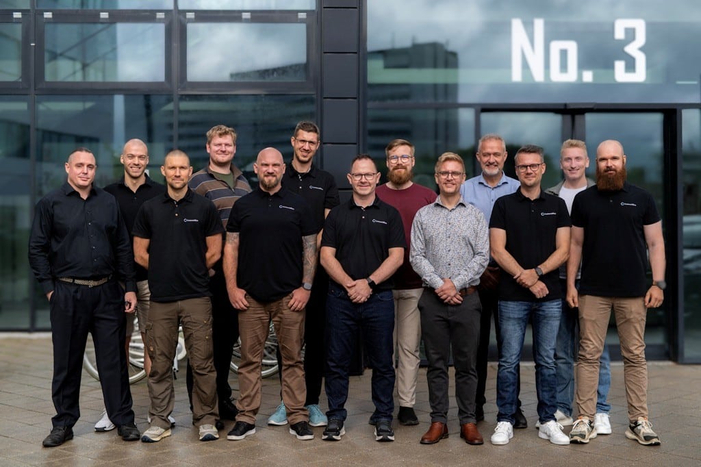 CustomOffice team billede udenfor kontoret, smilende medarbejdere.